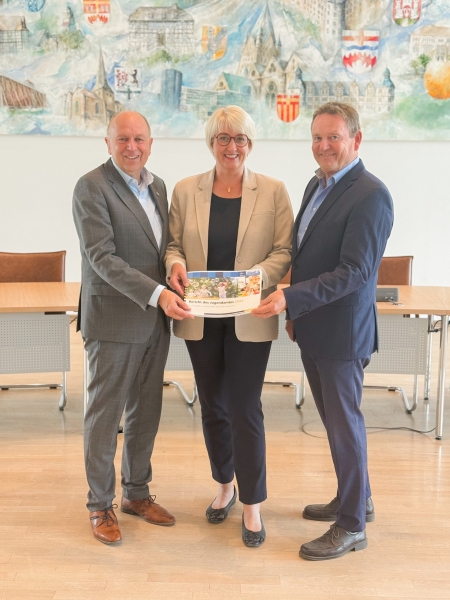 Landrat Christoph Rüther, Annette Mühlenhoff (zuständige Dezernentin) und Jugendamtsleiter Günther Uhrmeister mit dem Geschäftsbericht des Jugendamtes 2024 (v.l.). © Kreis Paderborn